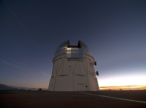  בתמונה: כיפת הכסף של טלסקופ בלנקו שקוטרו 4 מטרים המאחסן גם את DECam במצפה הבין אמריקני סרו טולולו בצ'ילה. צילום (Photo credit: T. Abbott and NOAO/AURA/NSF)