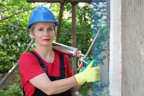امرأة تستخدم مسدسًا من مادة البولي يوريثين لإصلاح جدار. الرسم التوضيحي: شترستوك