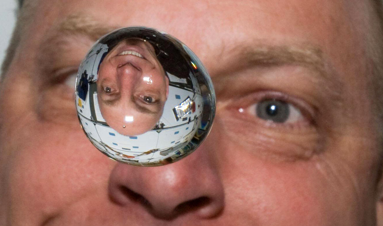 Astronaut Clayton Anderson watches a drop of water and its reflection in the space shuttle Discovery. The cohesion of water in microgravity is different than on Earth. Photo: NASA