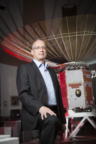 Yossi Weiss, CEO of Israel Aerospace Industries next to an observation satellite (Credit: Israel Aerospace Industries)