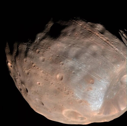 הירח פובוס המקיף את מאדים. בתצלום זה נראים היטב הסדקים על פניו, שההערכה היא שהם סימן ראשון להתפרקותו הצפויה. צילום: נאס"א