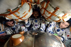 חברי הצוות ה-45 מתיישבים בחללית הסויוז שלהם לפני שובם לכדור הארץ. משמאל לימין: קייל לינגרן האמריקי, אולג קונוננקו מרוסיה וקימאיה יואי מסוכנות החלל היפנית