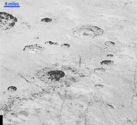 מכתש מצולק בפגיעות מטאוריטים שמאפשרים הצצה לנעשה מתחת לקרקע. צילום: החללית ניו הוריזונס של נאס"א