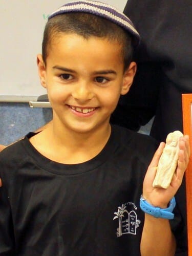 Uri Greenhut and the statuette he found. Photo: Miki Peleg, courtesy of the Antiquities Authority