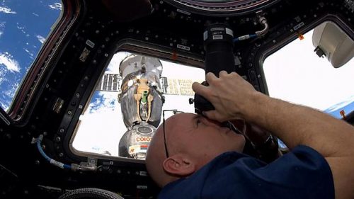 סקוט קלי מצלם את כדור הארץ מתא התצפית קופולה בתחנת החלל הבינלאומית. צילום: נאס"א