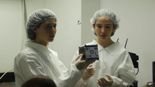 שתי תלמידות מחזיקות את הלווין הזעיר דוכיפת 1 (צילום: מרכז המדעים הרצליה)