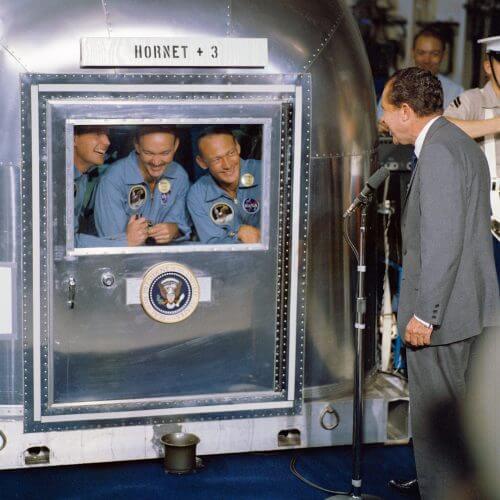 הנשיא ריצ'ארד ניקסון מבקר את האסטרונאוטים של אפולו 11 לאחר שובם מן הירח, בעת ששהו בבידוד בספינת חיל הים הורנט. צילום ממשלתי