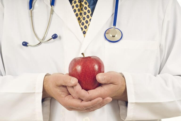 Doctor holding an apple. Illustration courtesy of the Cancer Society