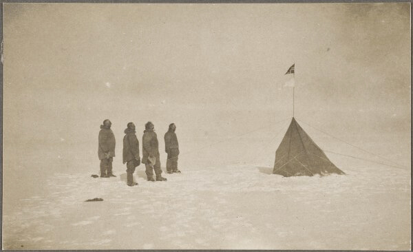 رولد أموندسن وفريقه يشاهدون العلم النرويجي في القطب الجنوبي، 14 ديسمبر 1911. من ويكيبيديا