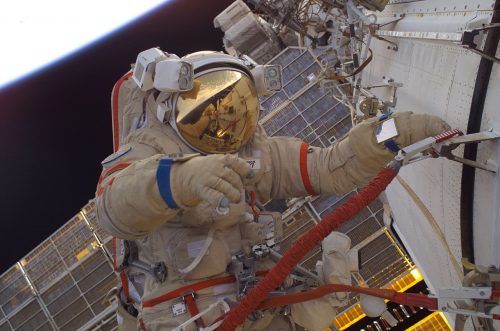 אסטרונאוט אמריקאי לבוש בחליפת אורלן רוסית, בתחנת החלל הבינלאומית, 2005. צילום: NASA/Sergei Krikalev.