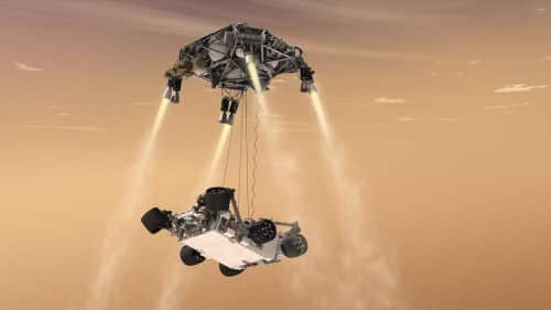 Simulation of one of the final stages of the landing: the "Sky Crane" hovered above the ground and lowered Curiosity to the ground by means of a cable. Source: NASA.