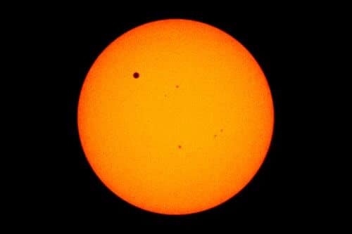 כוכב הלכת נוגה מופיע כנקודה קטנה בפינה השמאלית העליונה כאשר הוא עובר בין השמש לכדור הארץ בשנת 2012. צילום: נאס"א.
