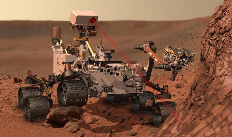 Simulation of the Curiosity rover firing a laser beam at a rock on Mars. The laser vaporizes part of the rock, and the rover examines the radiation spectrum of the resulting plasma, in order to determine the chemical composition of the rock. Source: NASA / JPL.