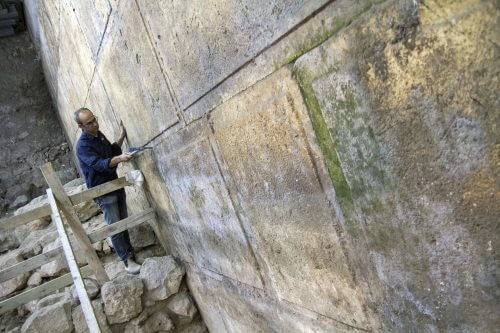 Israel Antiquities Authority archaeologist Dr. Joe Uziel Israel Antiquities Authority next to the stones of the Kotel that were uncovered in the excavation. Photo: Yaniv Berman, courtesy of the Israel Antiquities Authority.
