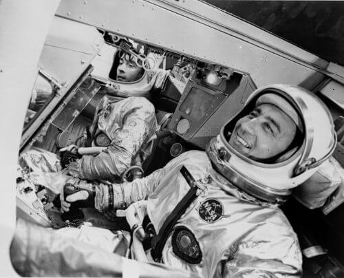 ג'ון יאנג (משמאל) וגאס גריסום, בסיפון החללית ג'מיני 3. יאנג הבריח בטיסה זו סנדוויץ' בקר כבוש, וננזף בשל כך על ידי הסוכנות. מקור: NASA.
