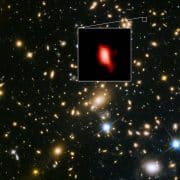 תמונה זו מראה את מקבץ הגלקסיות MACS J1149.5 + 2223 שצולם באמצעות טלסקופ החלל 'האבל' של NASA / ESA. התמונה בריבוע ההגדלה היא הגלקסיה הרחוקה MACS1149-JD1, כפי שנראתה לפני 13.3 מיליארד שנים ונצפתה לאחרונה על ידי 'אלמה'. ריכוז החמצן שגילה 'אלמה' מתואר בצבע אדום. צילום: ESO