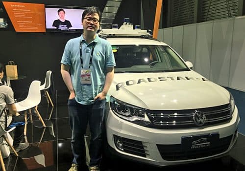 שיאנצ'או טונג, מנכ"ל ומייסד במשותף של Roadstar AI, ליד רכב עם הטכנולוגיה של החברה בכנס CES Asia. צילום: אבי בליזובסקי