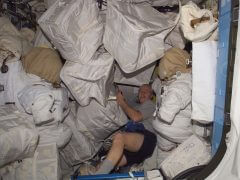 האסטרונאוט ג'ון פיליפס מדגים את בעיית הפסולת בתחנת החלל הבינלאומית, בשנת 2011. צילום: נאס"T
