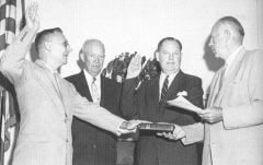 דריידן (משמאל) וגלנאן (שני מימין) מושבעים לתפקידם כשהנשיא אייזנהאור מתבונן (שני משמאל). צילום נאס:א