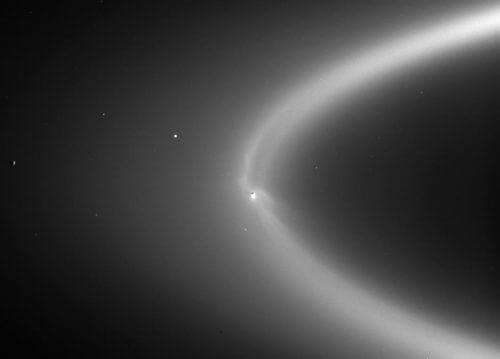 אֶנקֶלַדוּס (במרכז) כפי שהוא נראה ממרחק של שני מיליון קילומטרים. הירח משובץ בטבעת E של שבתאי, הנוצרת מתמרת הקרח שהוא פולט. מקור: NASA/JPL/Space Science Institute.