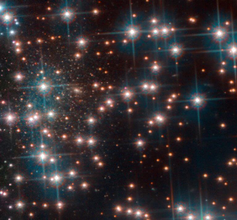 תמונה זו, שצולמה על ידי המצלמה המתקדמת של האבל לסקרים, מציגה חלק מהצביר הכדורי NGC 6752. מאחורי הכוכבים הבהירים של האשכול, יש אוסף צפוף של כוכבים חלשים למראה. הם שייכים לגלקסיה ננסית ספירואידית שלא היתה ידועה עד כה. גלקסיה זו, המכונה Bedin 1, נמצאת כ -30 מיליון שנות אור מכדור הארץ. צילום: ESA/Hubble, NASA, Bedin et al.