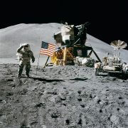 האסטרונאוט ג'יימס אירווין על רקע דגל ארה"ב, מודול הירח של אפולו 15, ורכב השטח עליו נסעו במרחבי הירח. צילום: נאס"א