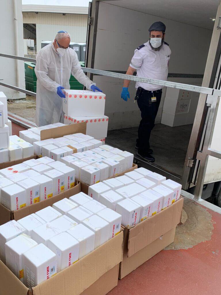 Prof. Robert Flor, director of the Israeli National Center for Personalized Medicine at the Weizmann Institute of Science, receives the first shipment of tests that arrived at the institute. Photo: Weizmann Institute Spokesperson