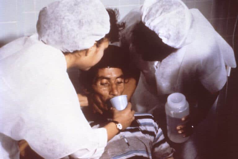 חולה קורונה מקבל טיפול בתרופה שתמנע התייבשות, ב-1992. תמונה: נחלת הכלל מתוך ויקיפדיה Cholera patient being treated by oral rehydration therapy in 1992