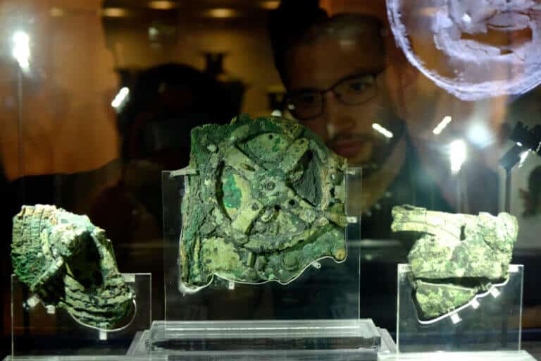 Visitors look at a fragment of the 2,100-year-old Antikythera Mechanism, believed to be the earliest surviving mechanical computing device. The photo was taken in a museum in Athens, Greece. Photo: shutterstock