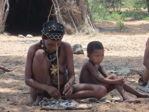 A Kong woman makes jewelry next to a boy. Stahler/Wikimedia