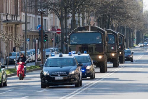 April 04, 2020. Italian army trucks transport the bodies of those killed in Bergamo (Italy) due to corona virus infection to the Shrine of the Fire in Ferrara, Italy. Photo: Shutterstock filippo.rubin