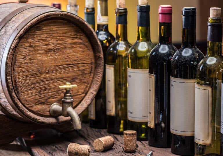 Wine bottles and a wine barrel made of oak wood. Image: depositphotos.com