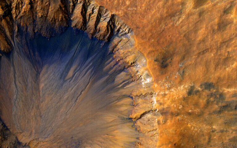 מצלמת ה-HiRISE שבמקפת לסקר מאדים של נאס"א צילמה את תמונת התקריב הזאת של מכתש פגיעה "חדש" (בקנה מידה גיאולוגי, אבל עתיק מאוד בקנה מידה אנושי) באזור סירנום פוסיי של מאדים ב-30 במרץ 2015. צילום: נאס"א