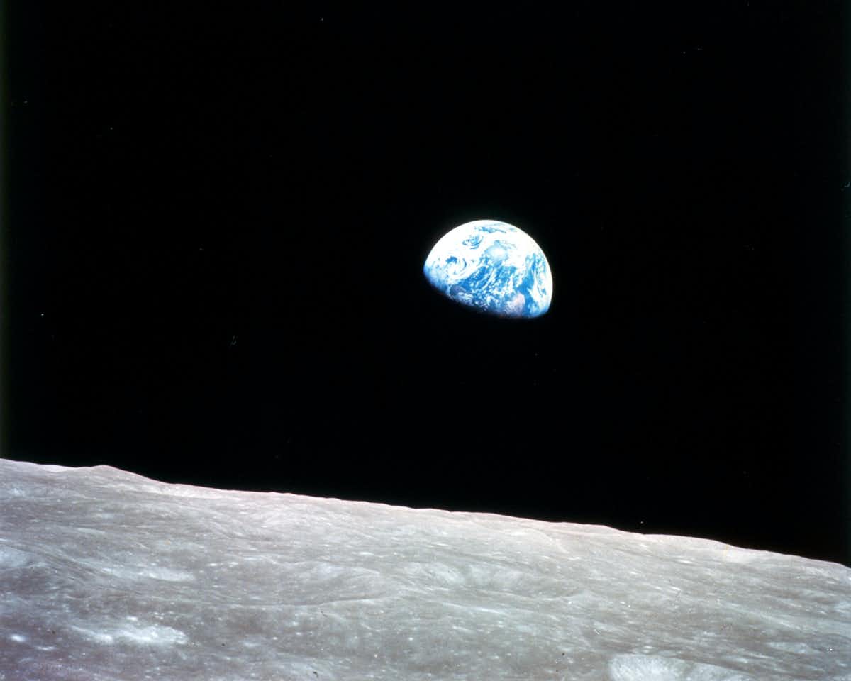 תמונה זו של כדור הארץ, שנראה עולה מעל אופק הירח, צולמה על ידי צוות אפולו 8 בערב חג המולד 1968. ויליאם אנדרס/נאס"א , CC BY-SA