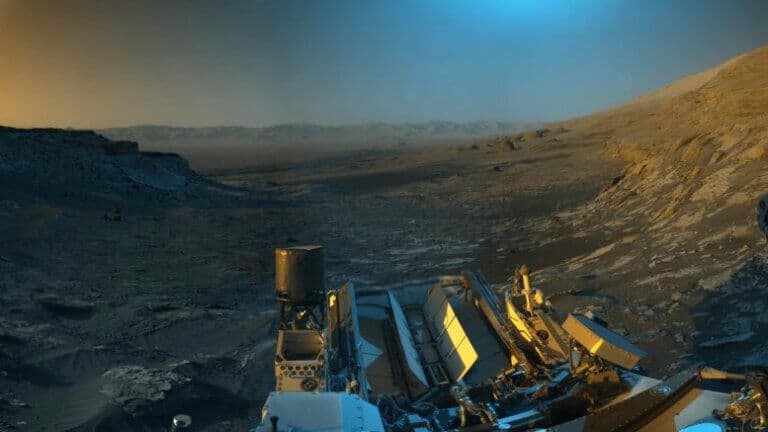 רכב המאדים קיוריוסיטי של נאס"א השתמש במצלמות הניווט שלו כדי לצלם תמונות פנורמיות של הנוף הזה. הוסיפו צבע כחול, כתום וירוק לשילוב של התמונות הפנורמיות לשם פרשנות אמנותית של הנוף. קרדיט: NASA/JPL-Caltech