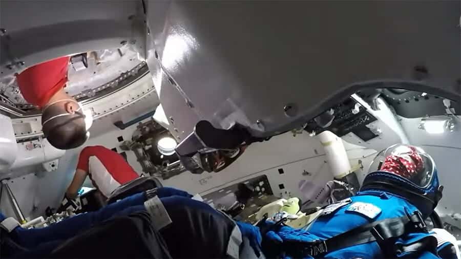 NASA astronauts Bob Hines and Kjell Lindgren greet "Rosie the Rocketeer" inside the Boeing Starliner spacecraft shortly after opening its hatch.