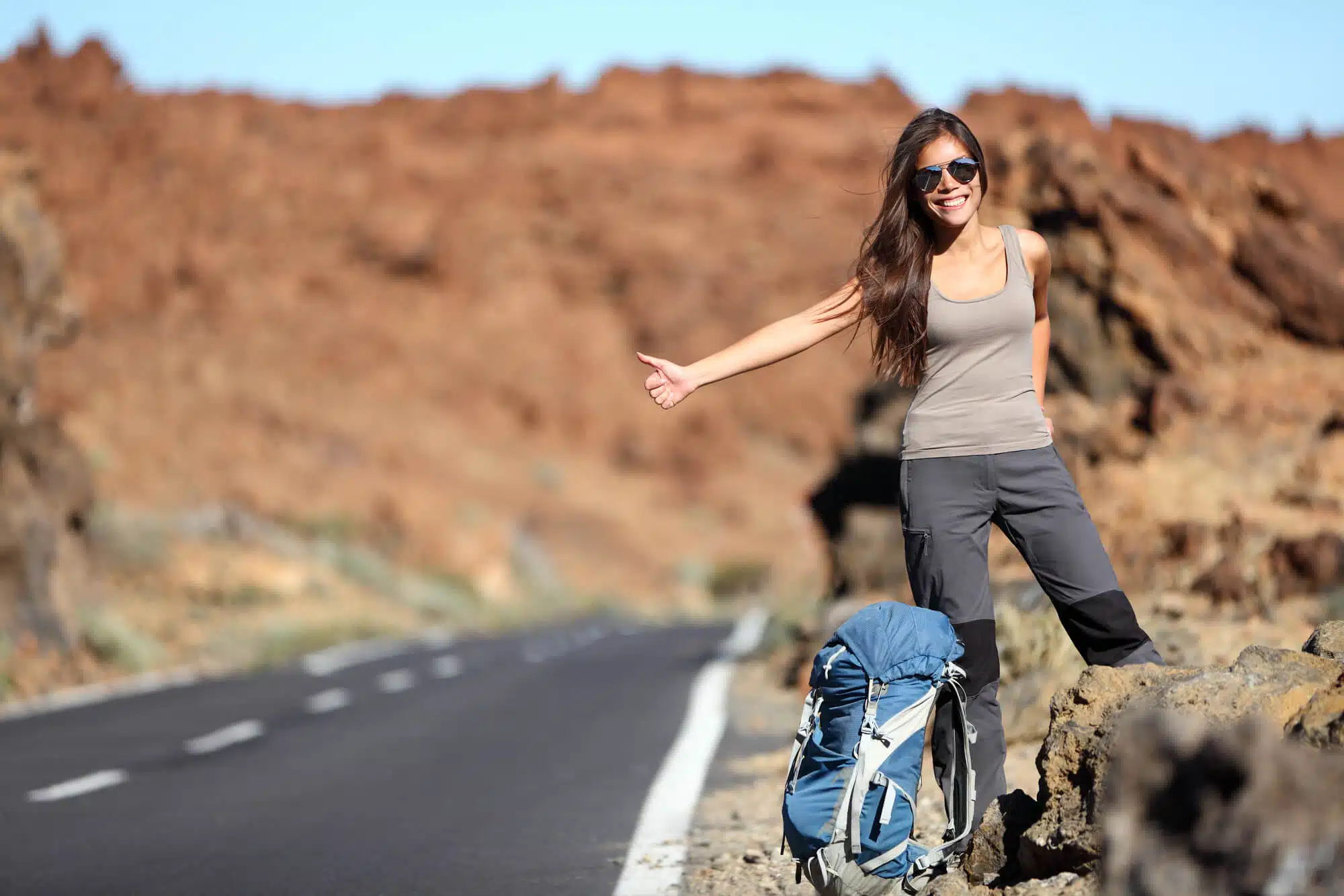 A woman hitchhikes. Image: depositphotos.com