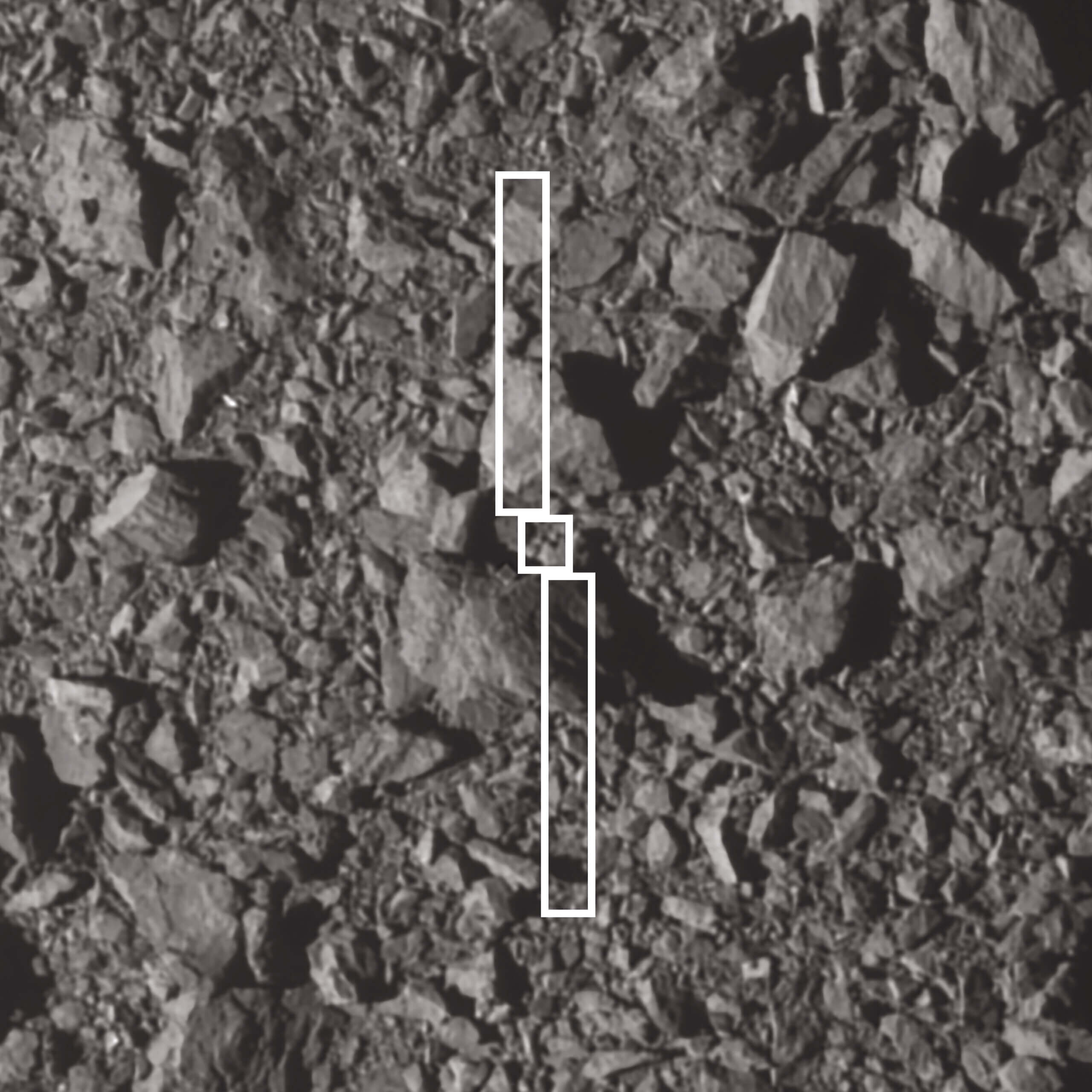 تُظهر هذه الصورة أثر المركبة الفضائية DART ولوحيها الشمسيين الطويلين فوق النقطة التي اصطدمت فيها بكويكب ثنائي الشكل. ويبلغ عرض الصخرة الأكبر بالقرب من موقع الارتطام حوالي 6.5 متر. التقطت DART الصورة قبل ثلاث ثوان من الاصطدام. المصدر: ناسا/جونز هوبكنز APL