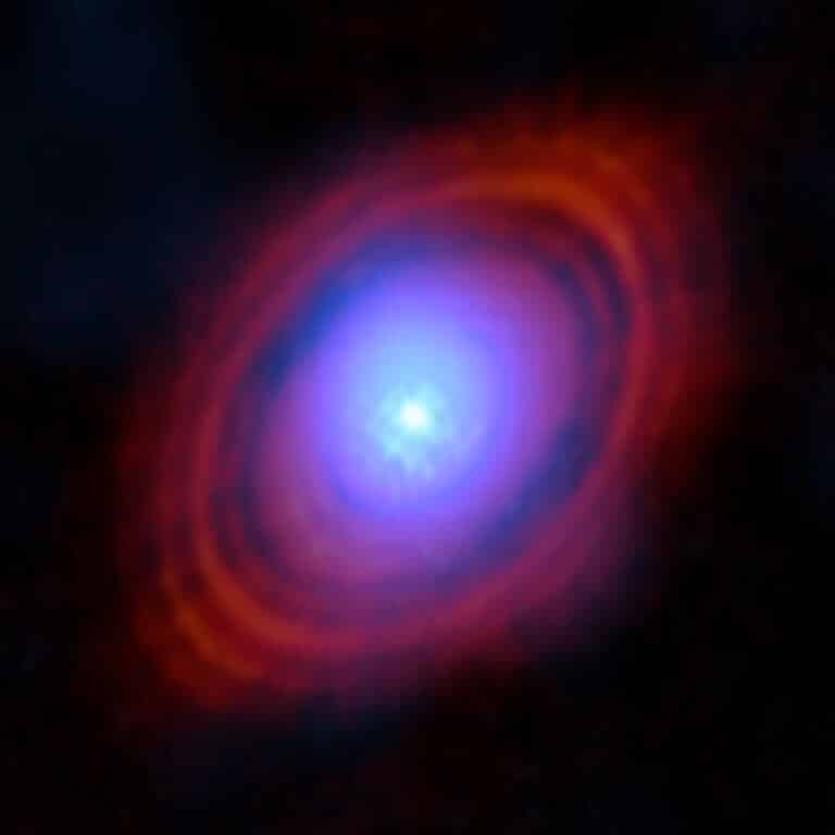 Astronomers have found water vapor in the disk around a young star right where planets are likely to form. In this image, the new observations from the ESO partner Atacama Large Millimeter/Submillimeter Array (ALMA) show the water vapor in shades of blue. Near the center of the disc, where the young star lives, the environment is hotter and the gas is brighter. The red rings are previous ALMA observations showing the distribution of dust around the star.Credit: ALMA (ESO/NAOJ/NRAO)/S. Facchini et al.