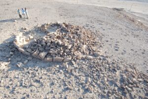Researchers examine the remains of a platform-shaped monument — the largest type of monument ever studied. Such monuments were usually built in one sitting, by multiple people. Credit: Ohio State University