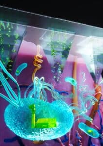 المفهوم الجديد – بكتيريا (باللون الأزرق الفاتح) تعمل كمصنع دوائي ينتج المكون النشط في العضو المستهدف (الجلد).