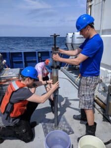 David Thornalley, Jack Wharton and Alice Carter-Champion divide a sediment core into 1cm sections aboard the research vessel (RV) Neil Armstrong, about 800km east of New York City. Credit: Alice Carter-Champion, UCL
