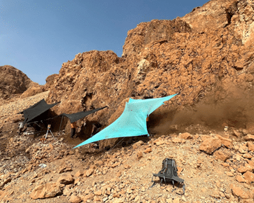 חפירה באתר ארכיאולוגי במערה במדבר יהודה, ניתן לראות את האבק שעולה מסינון הממצא נישא ברוח מימין לציליה הימנית. צילום: המעבדה לבוטניקה ארכיאולוגית, אוניברסיטת בר אילן.