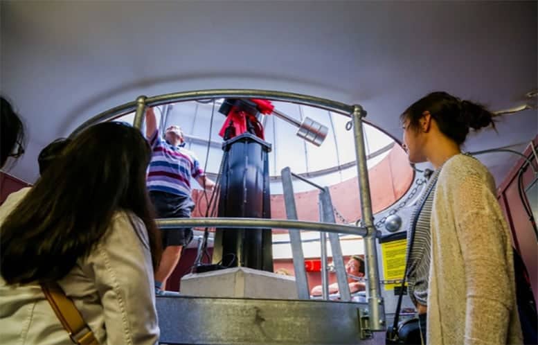 סטודנטים מאוניברסיטת קווין מרי בלונדון עובדים ליד טלסקופ בתוך כיפה