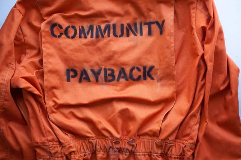 בגד אסיר כתום עם הכיתוב Community Payback